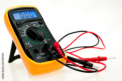 Digital multimeter with probes and blue backlit display on a white background photo