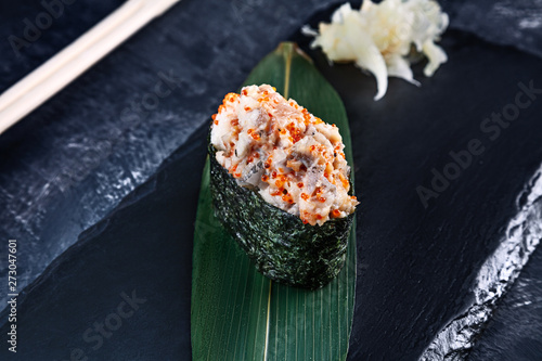 Close up view on gunkan sushi with spicy sauce and eel on dark stone background. Fresh Japanese cuisine. asian food. Sushi image for menu. Seafood, healthy food. raw photo