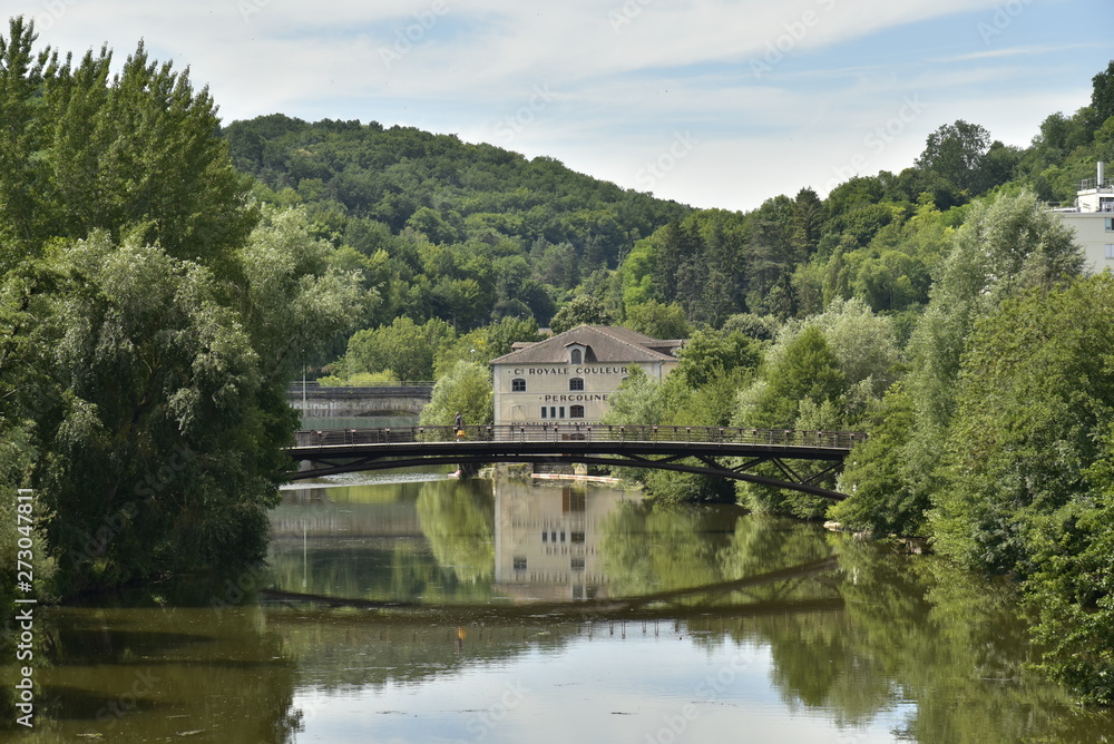 Reflet parfait du pont métallique et d'un bâtiment historique dans l'Isle au fond d'une vallée verdoyante en aval de Périgueux en Dordogne
