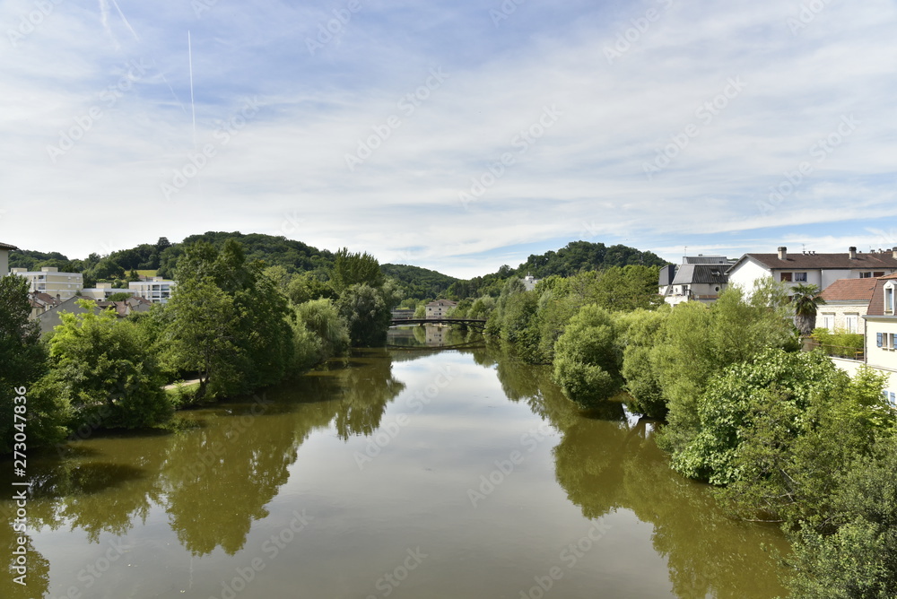 L'Isle avec ses reflets vers le pont métallique dans une vallée verdoyante en aval du centre historique de Périgueux en Dordogne