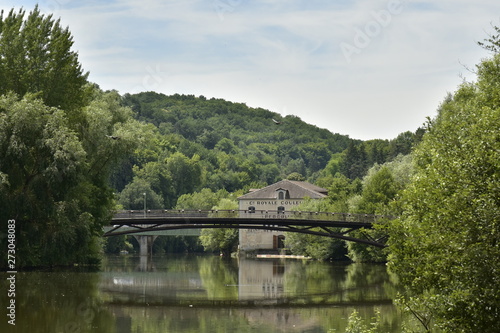 Reflet parfait du pont métallique et d'un bâtiment historique dans l'Isle au fond d'une vallée verdoyante en aval de Périgueux en Dordogne