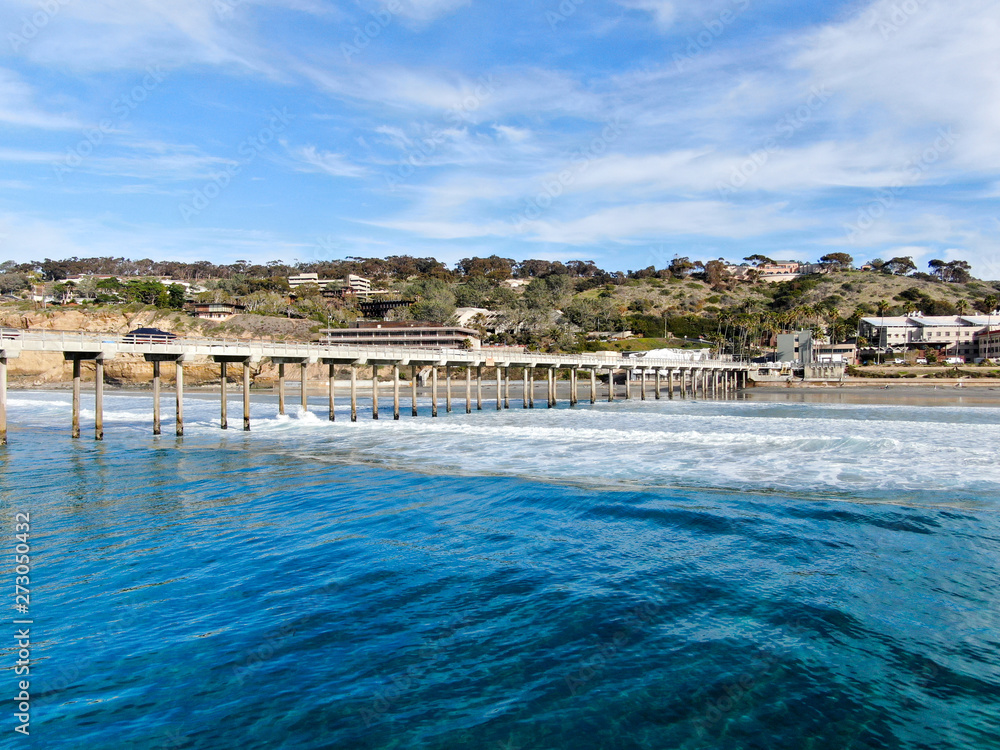 Aerial view of the scripps pier institute of oceanography, La Jolla, San Diego, California, USA. Research pier used to study ocean conditions and marine biology.  Pier with luxury villa on the coast.