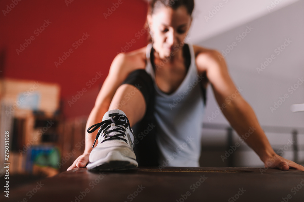 Fototapeta premium Young woman realizing indoor exercises with kettlebell