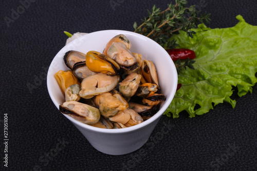 Pickled mussels in the bowl served pepper, garlic and salad