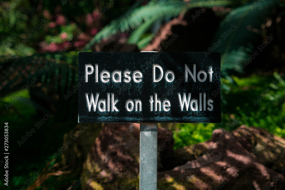 warning sign that reads please do not walk on the walls with a natural background