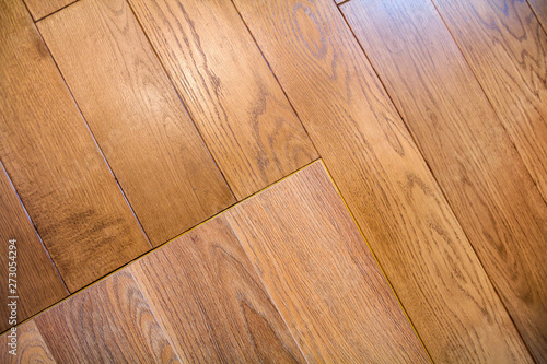Natural light brown wooden parquet floor boards. Sunny soft yellow texture  copy space perspective background.