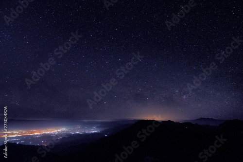 Mountain view morning at night of top hills and city around with soft fog under the stars in dark sky background, Monzone View Point Doi Ang Khang, Chiang Mai, northern of Thailand.