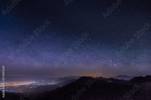 Mountain view morning at night of top hills and city around with soft fog under the stars in dark sky background, Monzone View Point Doi Ang Khang, Chiang Mai, northern of Thailand. photo