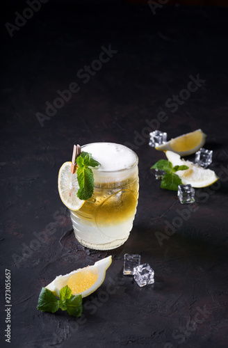 Moscow Mule Cocktail on a dark background. Cold drink, Layered white and yellow with vodka, spicy ginger beer, and lime juice. Selective focus.Cocktail card photo