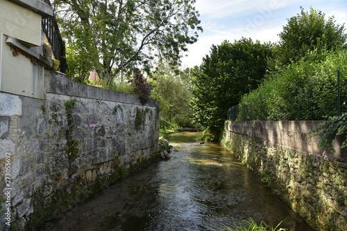 La rivière passant entre les vieux murs en pierres à Mareuil ,au Périgord Vert