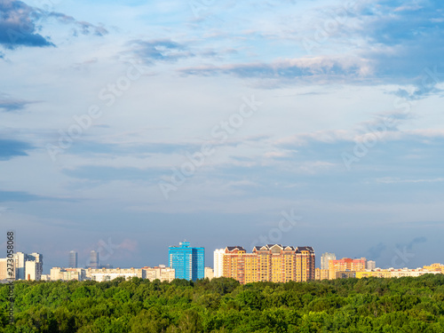 dark blue sky over city park and urban houses