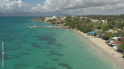 Scenic aerial view of La Datcha beach (Le Gosier plage) in Guadeloupe. Beautiful summer sunny look of small paradise tropical island in Caribbean sea. Several boats and yachts in blue sea.