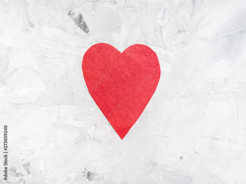 one heart cut from red paper on gray concrete one heart cut from red paper on gray concrete