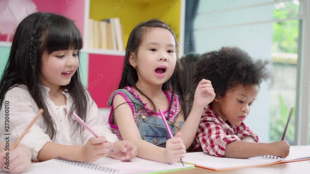 Slow motion - Group of children drawing in classroom, Multi-ethnic young boys and girls happy funny study and play painting on paper at elementary school. Kids drawing and painting at school concept. Slow motion - Group of children drawing in classroom, Multi-ethnic young boys and girls happy funny study and play painting on paper at elementary school. Kids drawing and painting at school concept.