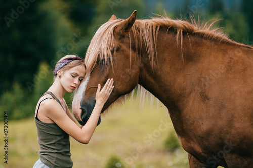 Young beautiful girl hugging horse at nature. Horse lover. © benevolente