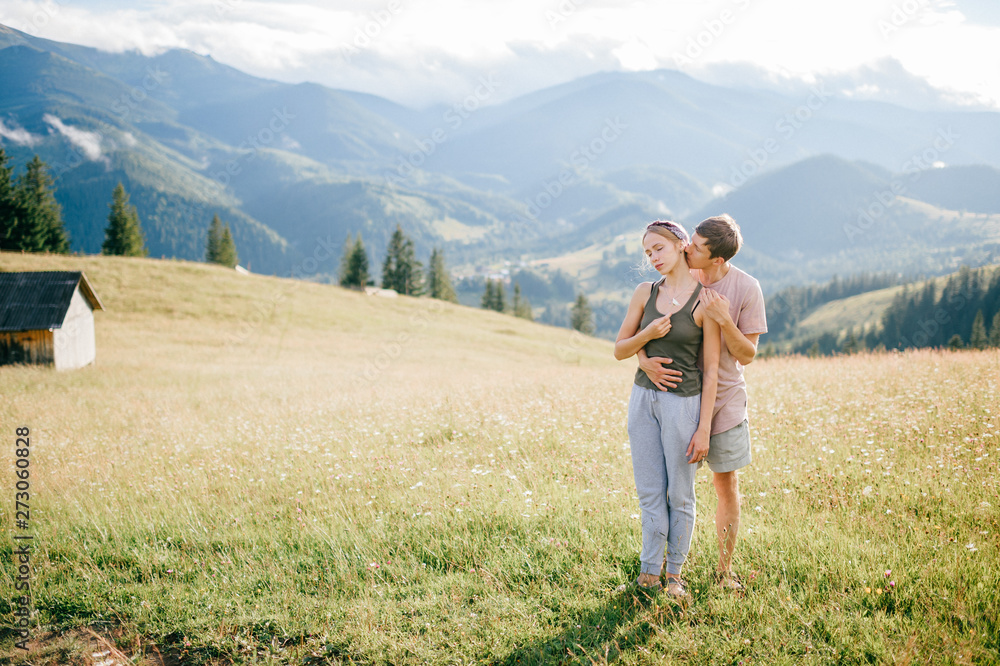 Fototapeta premium Lifestyle loving couple hugging at nature among mountains in summer.
