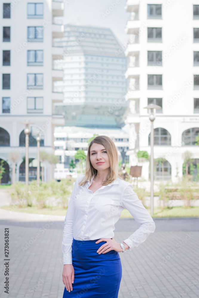 stylish business woman in blue jacket posing against a background of city streets stylish business woman in blue jacket posing against a background of city streets