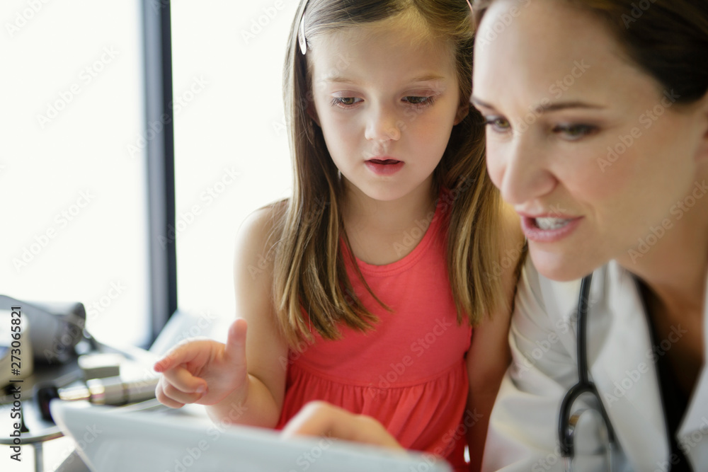 Close up of woman doctor and child looking at tablet Close up of woman doctor and child looking at tablet