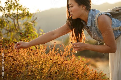 Young woman picks wildflowers
