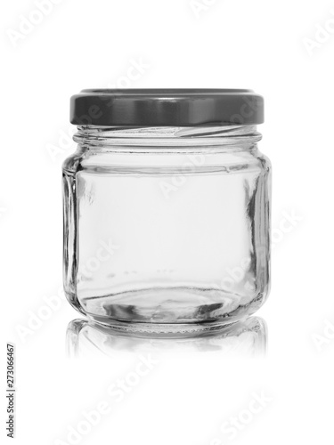 Small glass jar with a metal cover on a white background with reflection