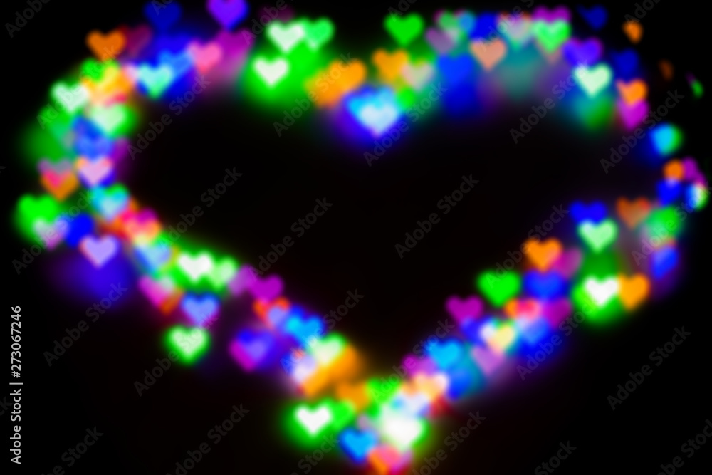 Blurred festive background with defocused colourful glitter formed a heart, bokeh in a shape of a heart. Original photographic effect. Pictures concept theme Love and St. Valentine's Day