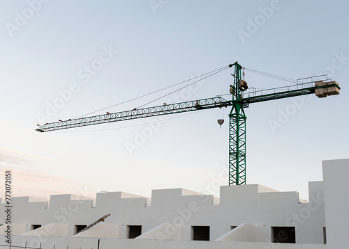 Silhouette of Tower construction crane and the building against a beautiful sky at sunset background