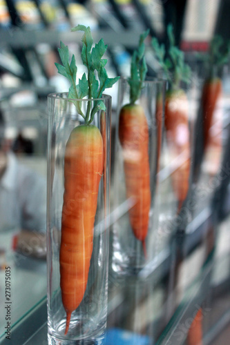 Quadro em tela Artificial carrots in long transparent glasses.