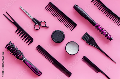 Fototapeta Naklejka Na Ścianę i Meble -  Combs, sciccors and hairdresser tools in beauty salon work desk on pink background top view pattern
