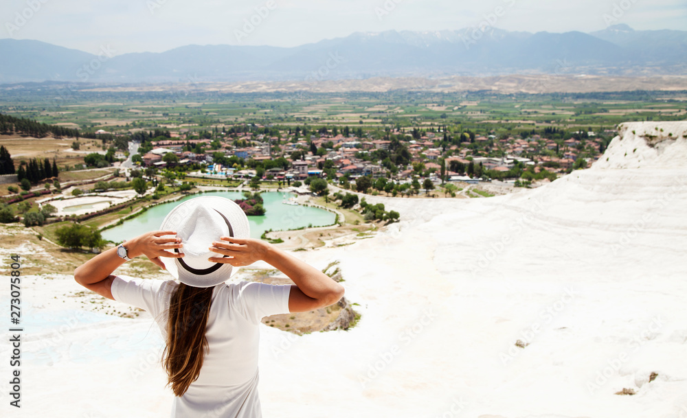 Natural travertine pools and terraces in Pamukkale. Cotton castle in southwestern Turkey, girl in white dress with hat natural pool Pamukkale