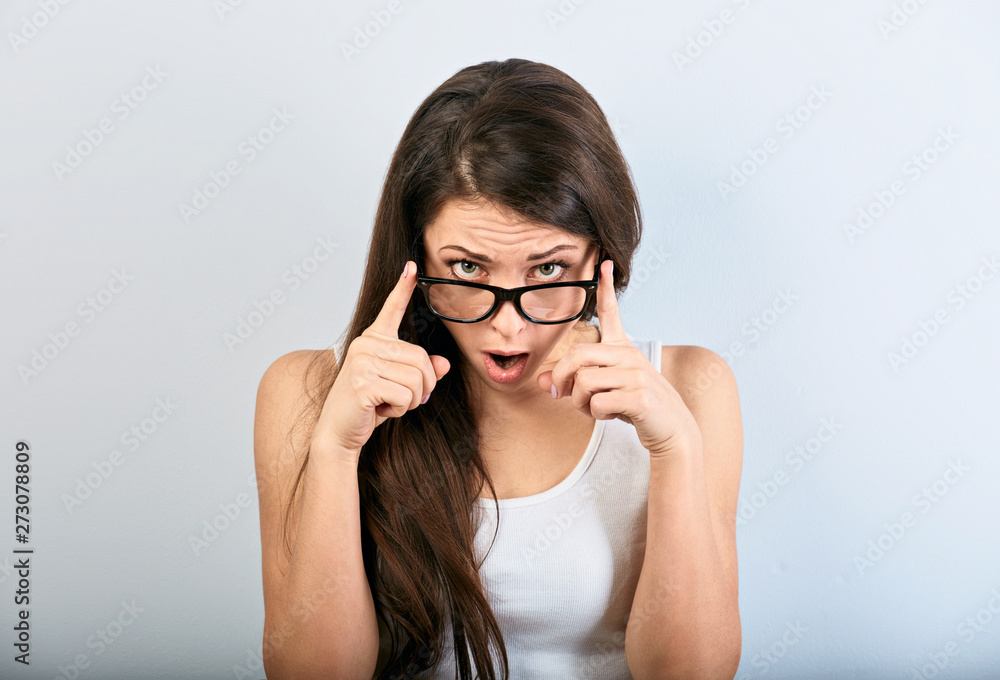 Shocked surprising woman in eyeglasses with open mouth looking on blue empty copy space background. Shocked surprising woman in eyeglasses with open mouth looking on blue empty copy space background.
