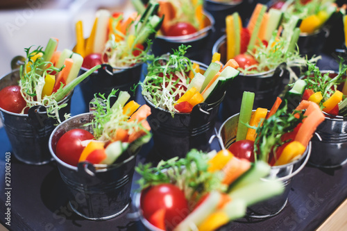 Beautifully decorated catering banquet table with variety of vegetables and different vegan vegetarian snacks on corporate christmas birthday party event or wedding celebration photo