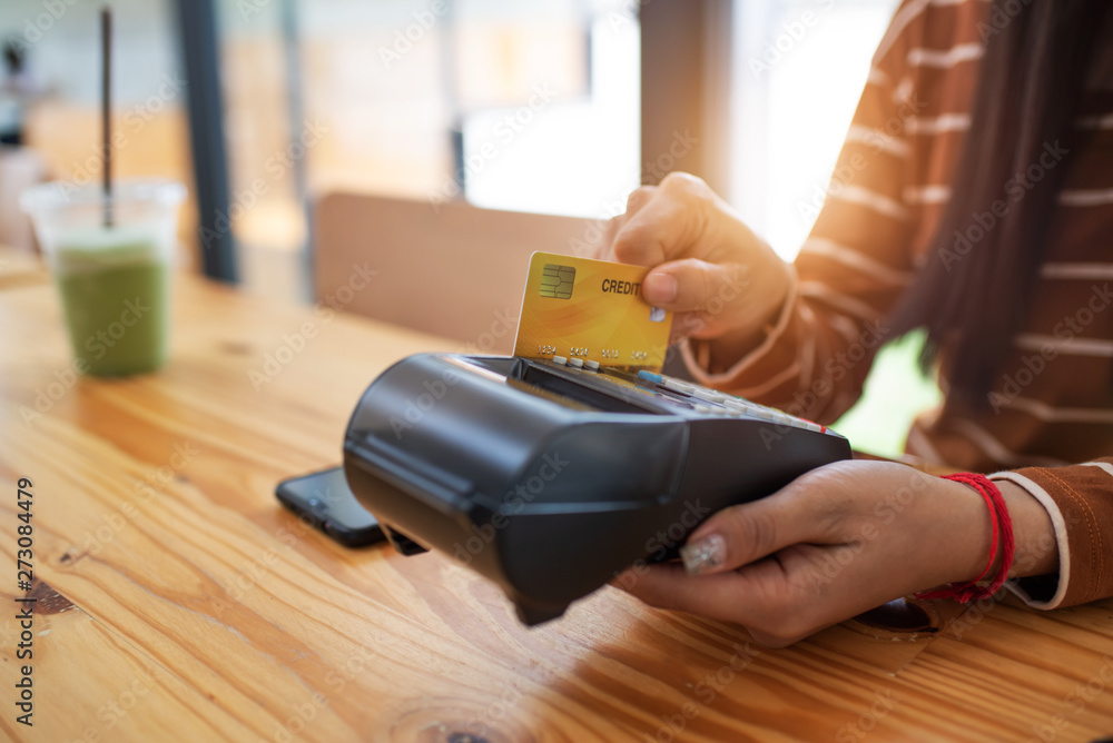 Fototapeta premium Young asian woman paying her order by credit card.