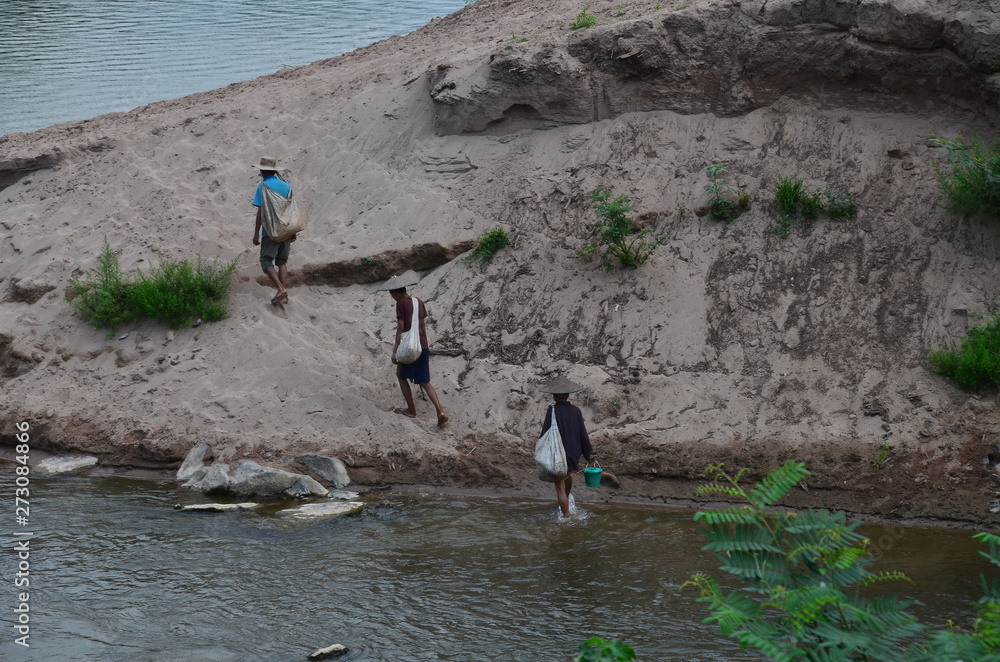 ラオス北部のノンキャウ 美しいウー川と森林 川を歩く村人 StockFoto Adobe Stock