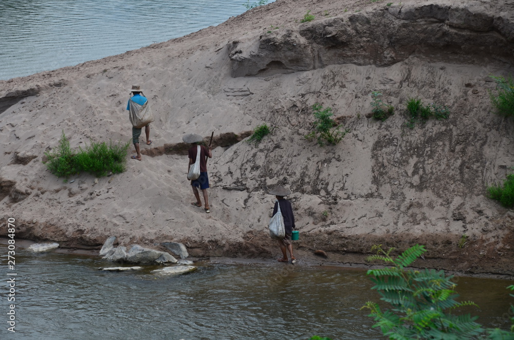 ラオス北部のノンキャウ 美しいウー川と森林 川を歩く村人 StockFoto Adobe Stock