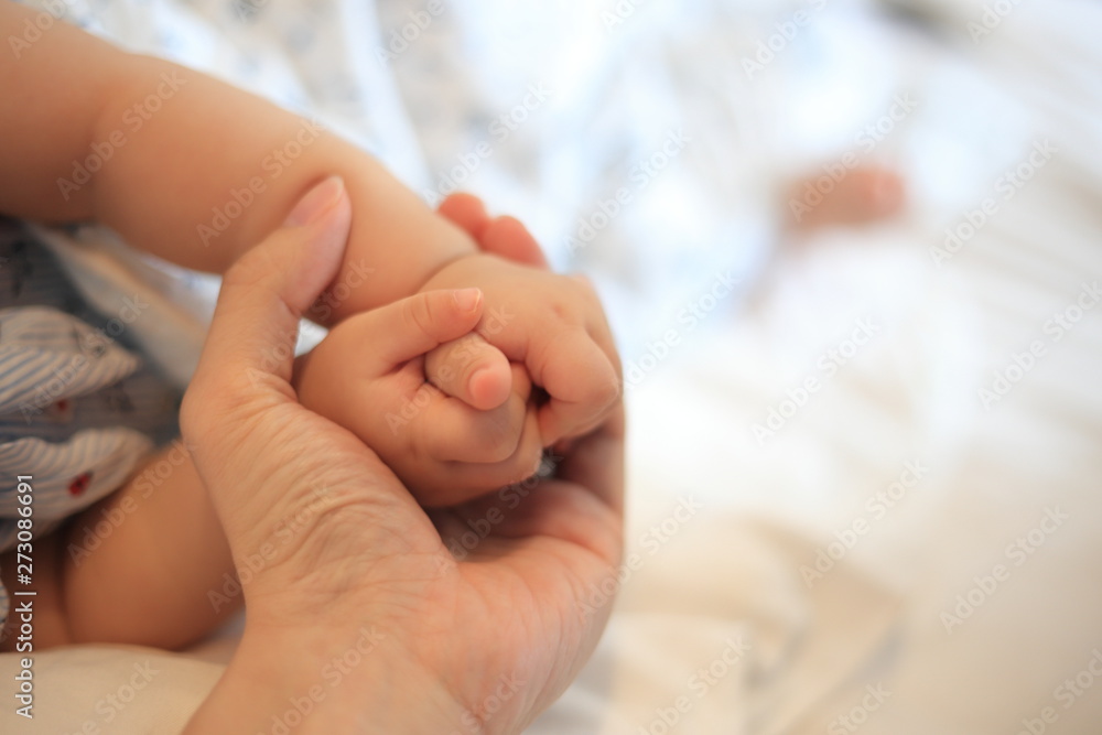 parent holding baby hands. small infant hands covered in father hand. love, care, support and comfort concepts. peaceful and loving family memory image.