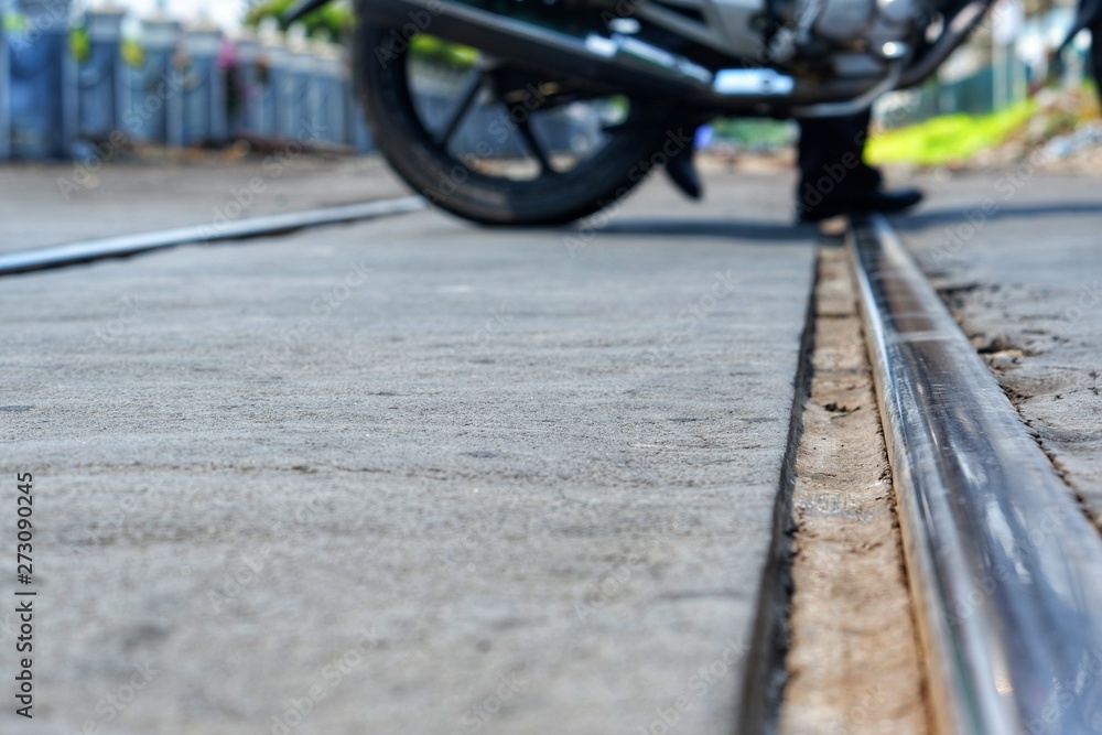 A man with his motorbike is crossing the railway A man with his motorbike is crossing the railway