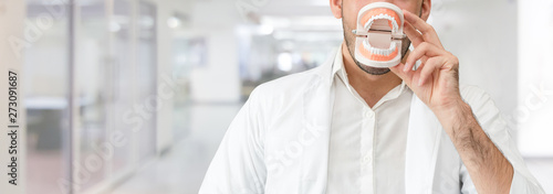 Young male dentist working in dental clinic. Dentistry care and medical service concept. photo