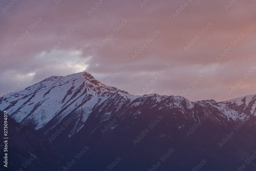 Snowy mountain with stormy red sunset sky