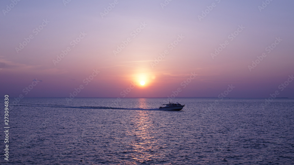 motorboat passes the sea at sunset