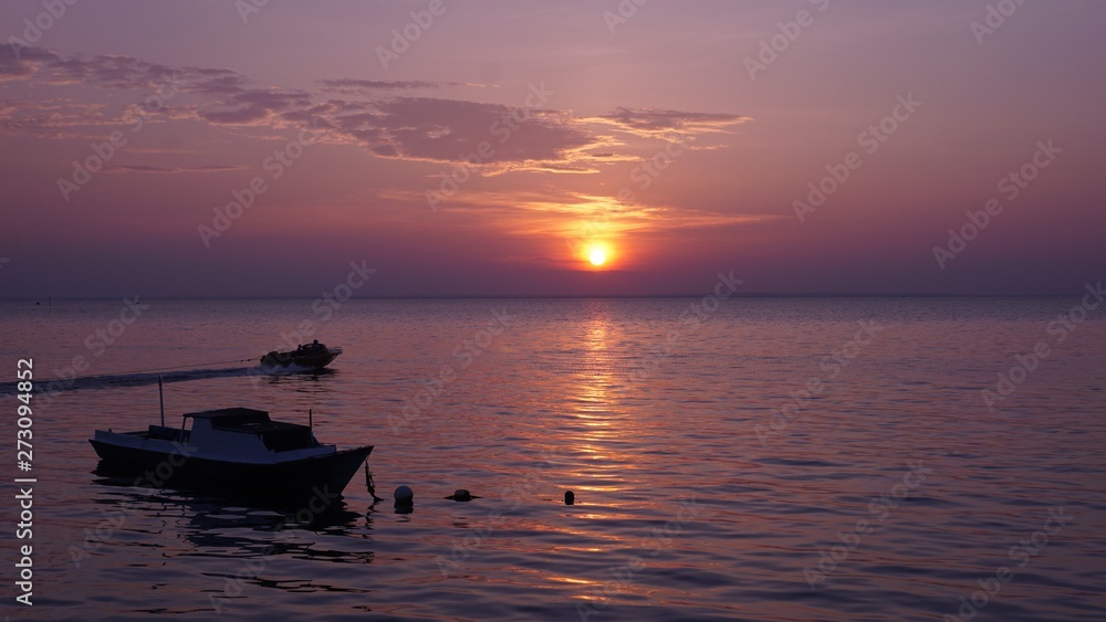 boats at sunset on the purple beach