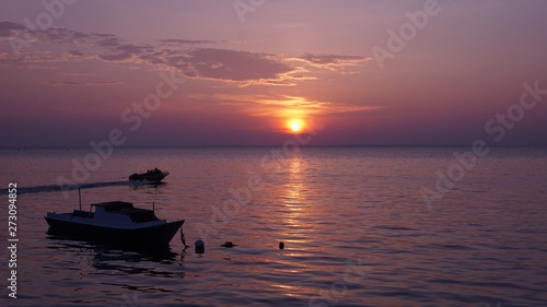 boats at sunset on the purple beach