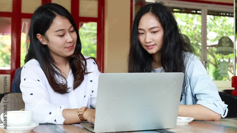 Asian woman talking together with friend in cafe Asian woman talking together with friend in cafe