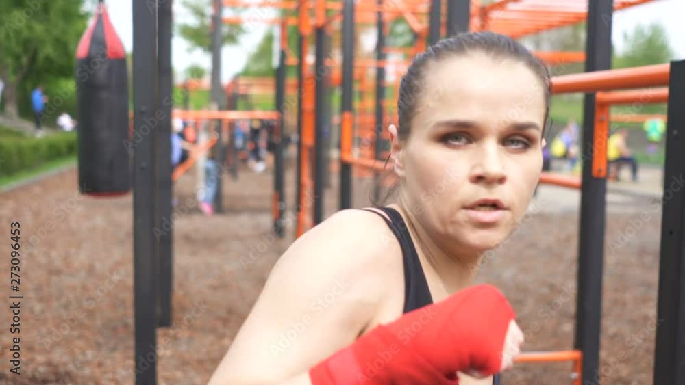 4К. Woman boxer training with shadow on street training ground. Face view ,steady shot 4К. Woman boxer training with shadow on street training ground. Face view ,steady shot