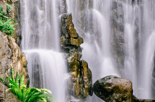 A close up view of cascading water falling over the rocks at Longshan Buddhist temple in Taipei city  Taiwan.