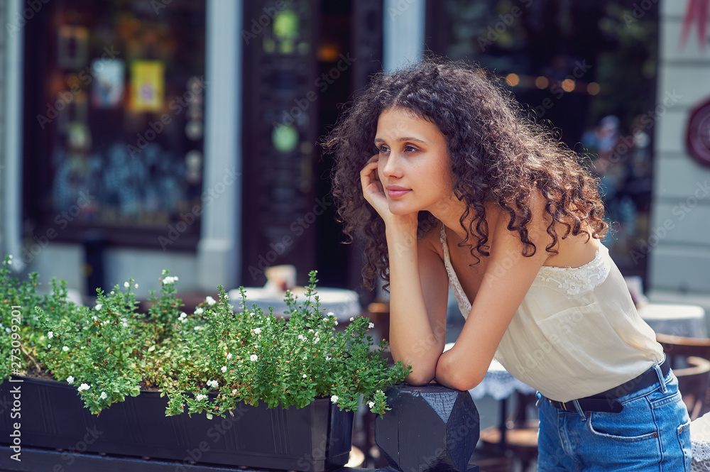 Beautiful young girl in summer in the city . The girl wears casual clothes , jeans and a light blouse Beautiful young girl in summer in the city . The girl wears casual clothes , jeans and a light blouse