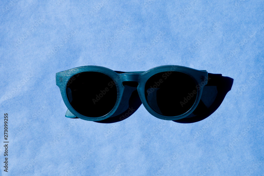 Stylish sunglasses with shadow on blue background. Stylish sunglasses with shadow on blue background.