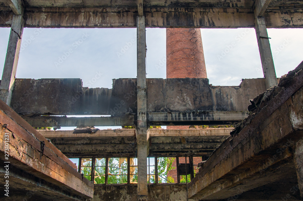 Obraz premium Destroyed building of the former boiler room.Red brick chimney.
