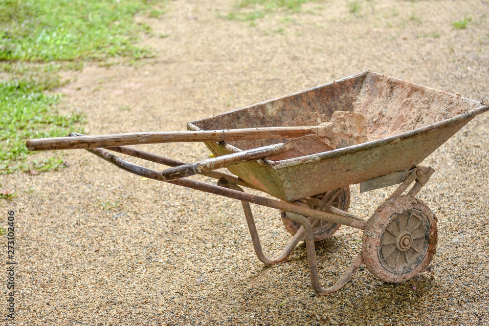 Two wheeled earth moving cart and tools for gardening after work in the farm. Two wheeled earth moving cart and tools for gardening after work in the farm.