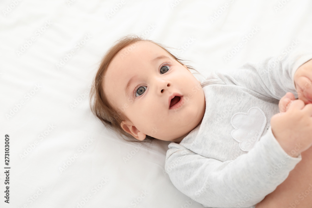 Portrait of adorable baby lying on bed. Space for text Portrait of adorable baby lying on bed. Space for text