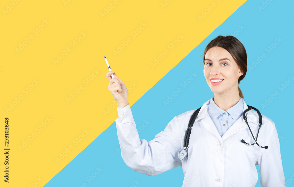 Smiling female doctor in white coat with stethoscope and clipboard pointing finger Smiling female doctor in white coat with stethoscope and clipboard pointing finger
